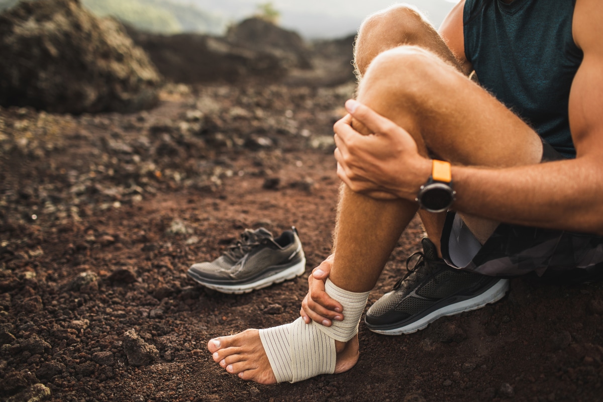 man with ankle wrapped on a hike